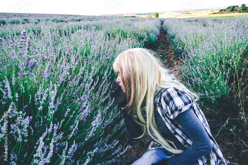 Young blonde woman alone in a lavender field photo