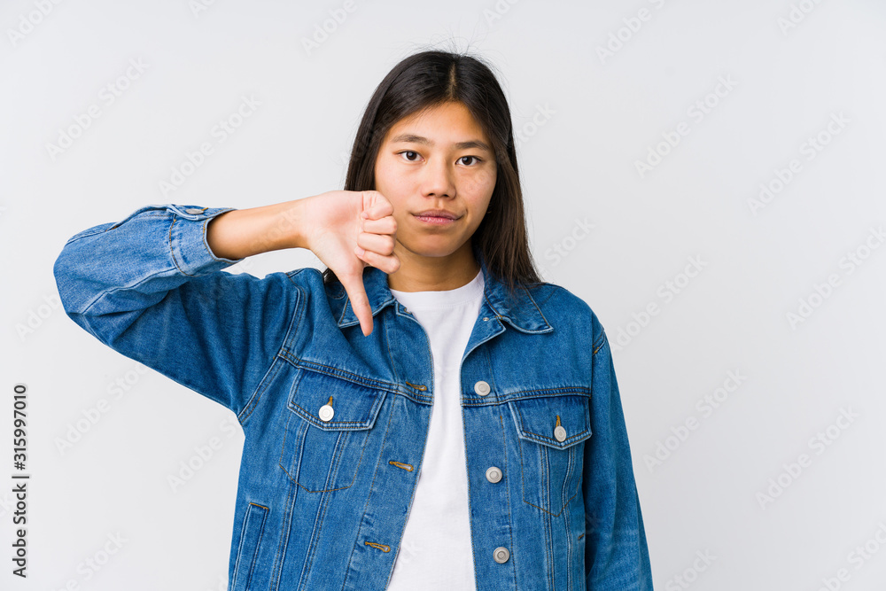 Young asian woman showing a dislike gesture, thumbs down. Disagreement concept. Young asian woman showing a dislike gesture, thumbs down. Disagreement concept.