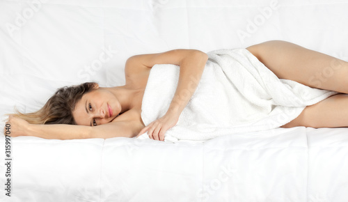 Woman Wrapped In White Towel Lying Down on Side