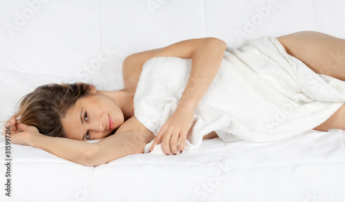 Woman Wrapped In White Towel Lying Down on Side