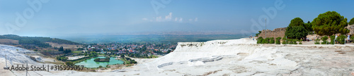 Panorama of the unique Pamukkale natural complex with white cliffs, an emerald lake, a picturesque village, ancient ruins and a beautiful valley.