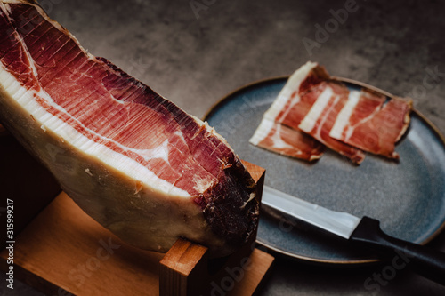 Iberian ham on a ham stand with knife and plate photo