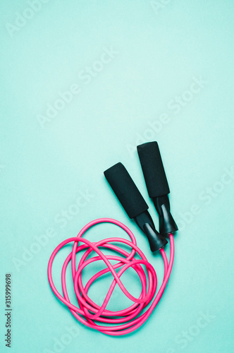Pink jump ropes on a green background, a concept of sports or weight loss