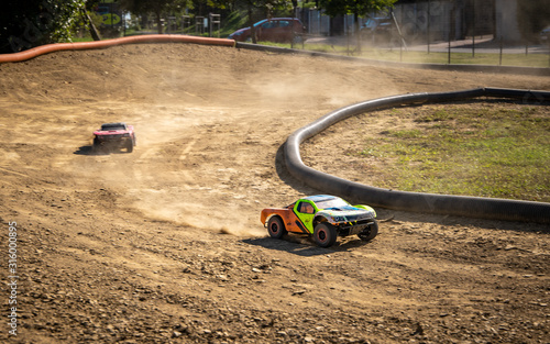 Two offroad RC cars racing on a track