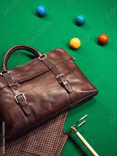 brown business men's leather bag on the pool table