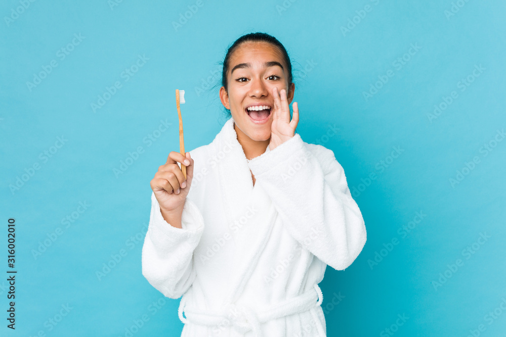 Young mixed race indian holding a toothbrush shouting excited to front. Young mixed race indian holding a toothbrush shouting excited to front.