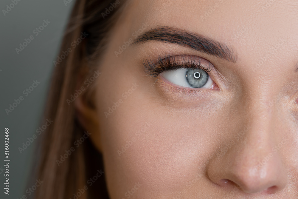 Macro of woman blue eye with false eyelashes. Vision correction Macro of woman blue eye with false eyelashes. Vision correction