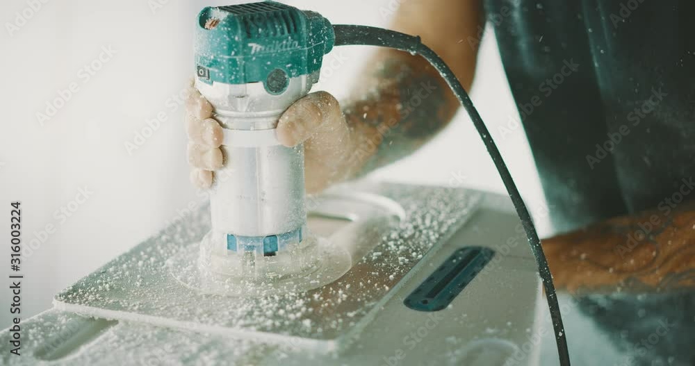 Close up view of a craftsman using a router power tool shaping a surfboard, skilled professional surfboard shaping craft Close up view of a craftsman using a router power tool shaping a surfboard, skilled professional surfboard shaping craft