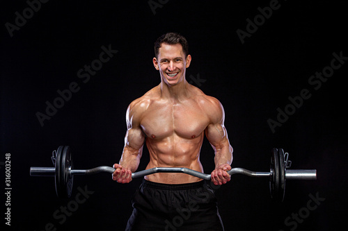 Athlete bodybuilder. Brutal strong muscular athletic man pumping up muscles with barbell on black background. Workout bodybuilding concept.