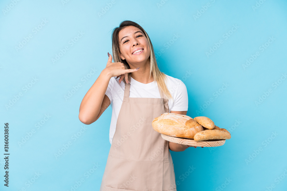 Young caucasian baker woman isolated showing a mobile phone call gesture with fingers. Young caucasian baker woman isolated showing a mobile phone call gesture with fingers.