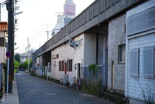 線路沿いに建つ長い倉庫と都会の建物