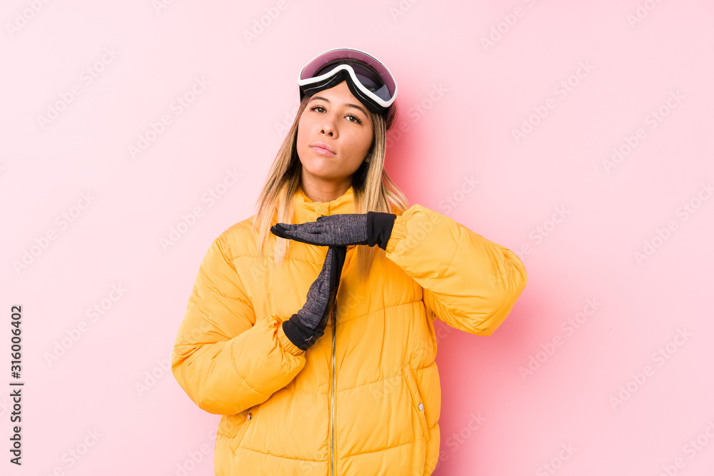Young caucasian woman wearing a ski clothes in a pink background showing a timeout gesture. Young caucasian woman wearing a ski clothes in a pink background showing a timeout gesture.