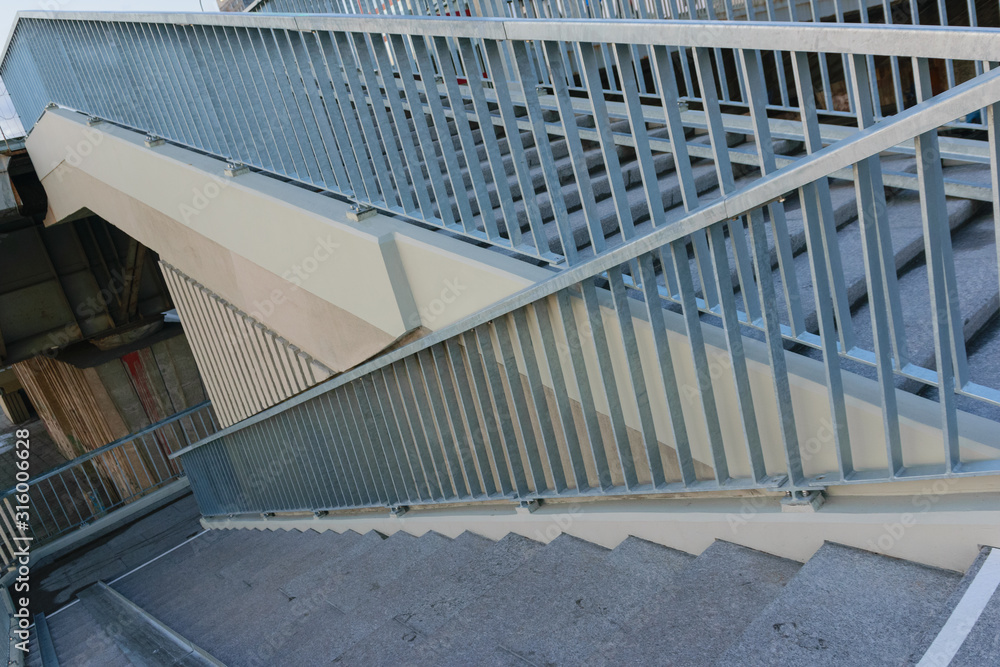 Fototapeta premium concrete staircase with metal railing descent from the bridge. down stair.