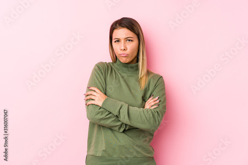 Young caucasian woman posing isolated  frowning face in displeasure, keeps arms folded. © Asier