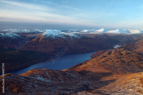 Snow covered mountain peaks and lake at sunset. Loch Lomond and The Trossachs National Park. Scotland