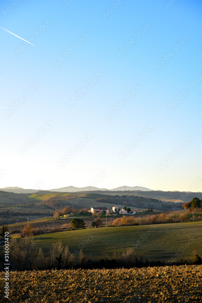 farm in the hills in the warm light of sunset. Countryside and agriculture in winter