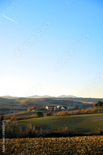 farm in the hills in the warm light of sunset. Countryside and agriculture in winter