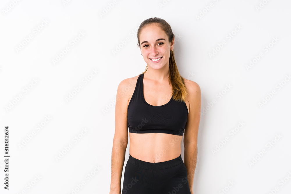 Young caucasian fitness woman posing in a white background happy, smiling and cheerful. Young caucasian fitness woman posing in a white background happy, smiling and cheerful.
