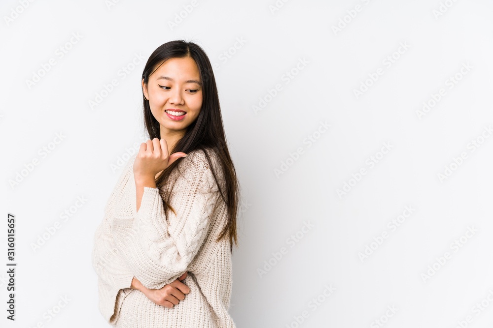 Young chinese woman isolated points with thumb finger away, laughing and carefree. Young chinese woman isolated points with thumb finger away, laughing and carefree.