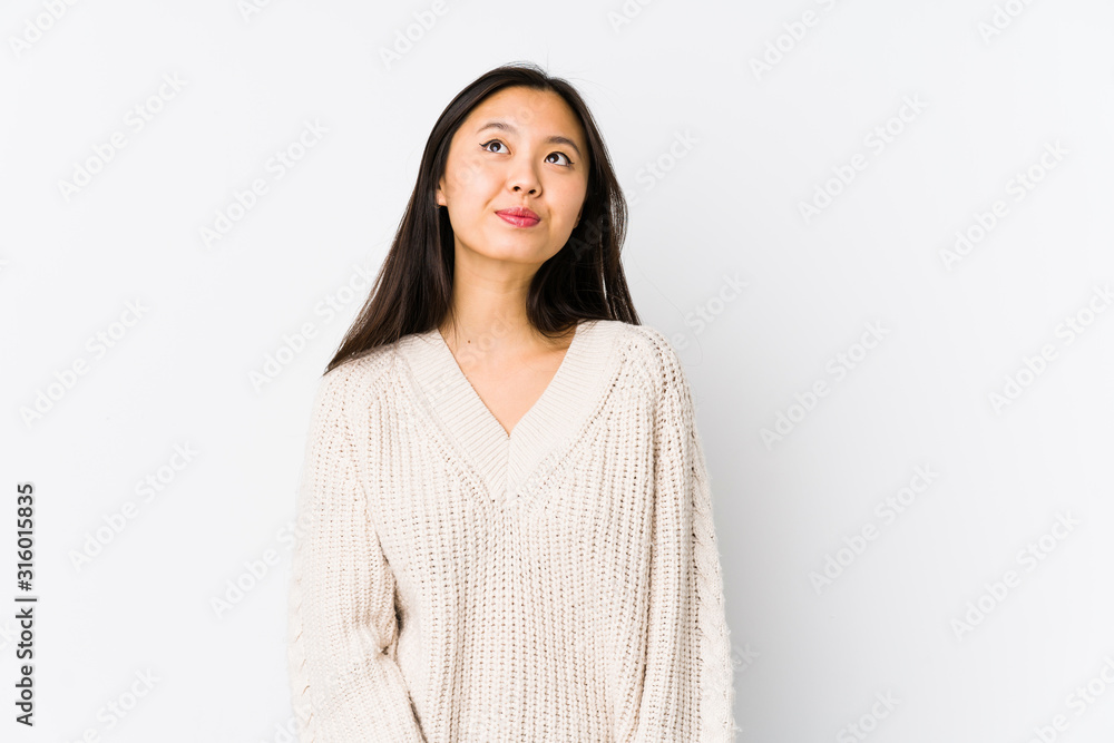 Young chinese woman isolated dreaming of achieving goals and purposes Young chinese woman isolated dreaming of achieving goals and purposes