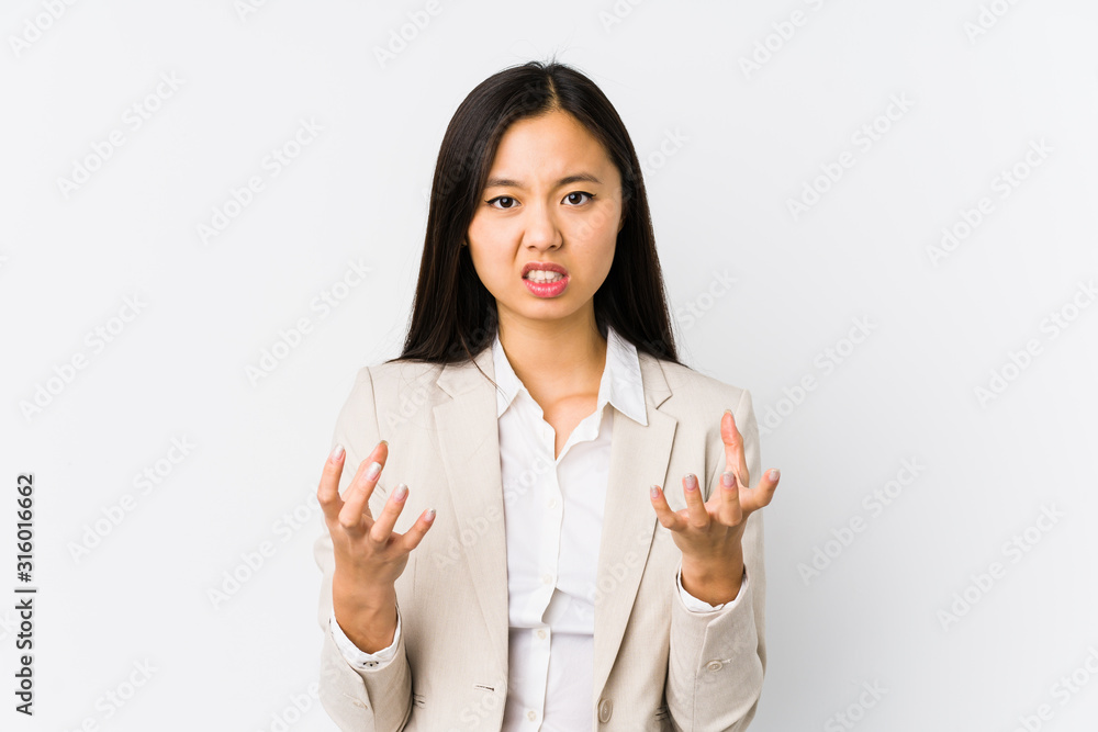 Young chinese business woman isolated upset screaming with tense hands.