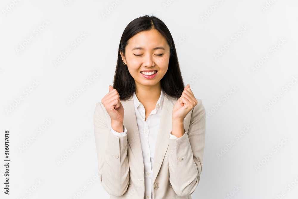 Young chinese business woman isolated raising fist, feeling happy and successful. Victory concept. Young chinese business woman isolated raising fist, feeling happy and successful. Victory concept.