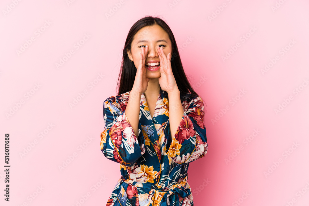 Young chinese woman wearing a kimono pajama isolated shouting excited to front. Young chinese woman wearing a kimono pajama isolated shouting excited to front.