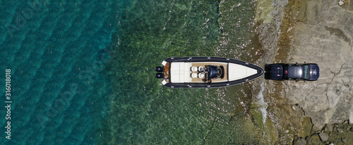 Slika na platnu Aerial top view ultra wide photo of inflatable speed boat on trailer being towed