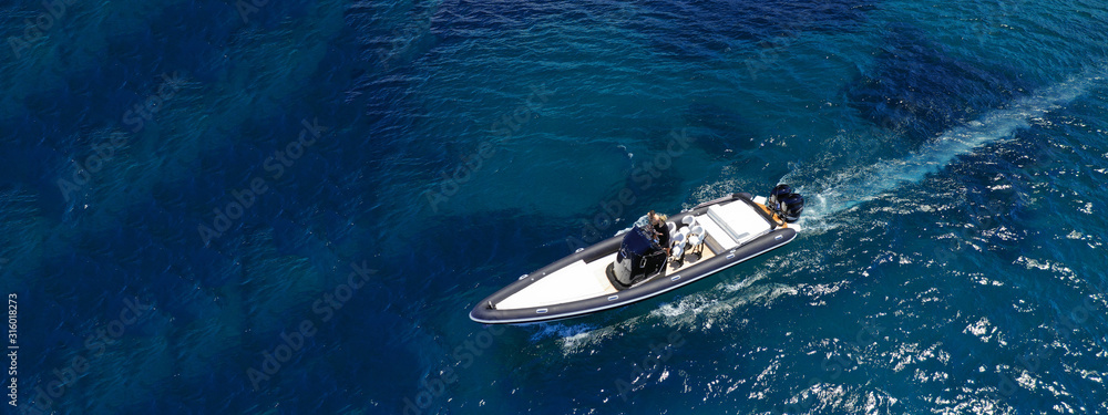 Fototapeta premium Aerial drone ultra wide top down photo of luxury rib inflatable with wooden deck cruising in deep blue open ocean sea