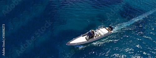 Aerial drone ultra wide top down photo of luxury rib inflatable with wooden deck cruising in deep blue open ocean sea © aerial-drone