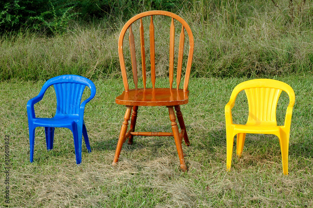 Three chairs in different sizes displayed outside.