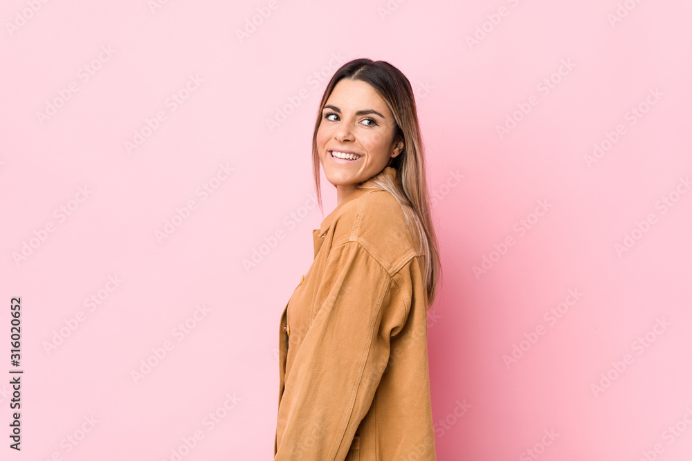 Young caucasian woman isolated looks aside smiling, cheerful and pleasant.