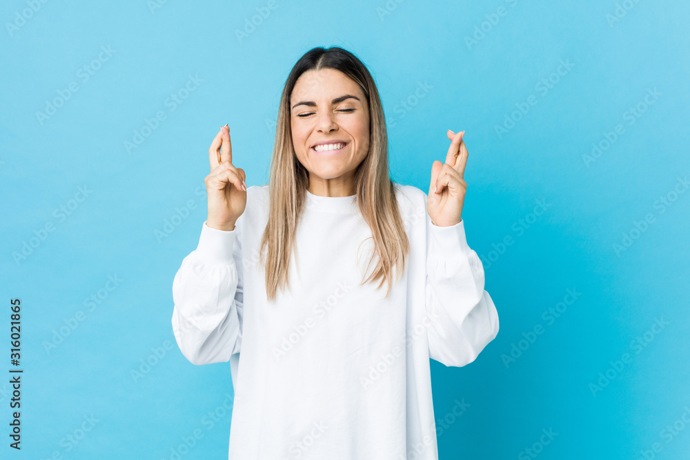 Young caucasian woman isolated crossing fingers for having luck Young caucasian woman isolated crossing fingers for having luck