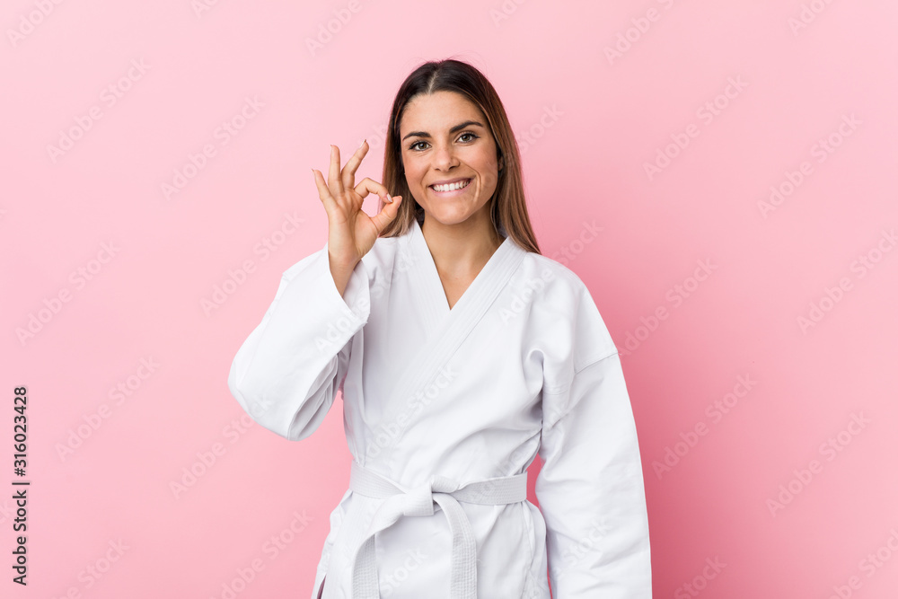 Young karate woman cheerful and confident showing ok gesture. Young karate woman cheerful and confident showing ok gesture.