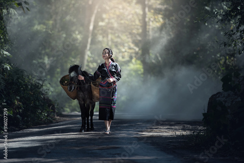 Asian woman worker with her donkey in forest countryside of Thailand