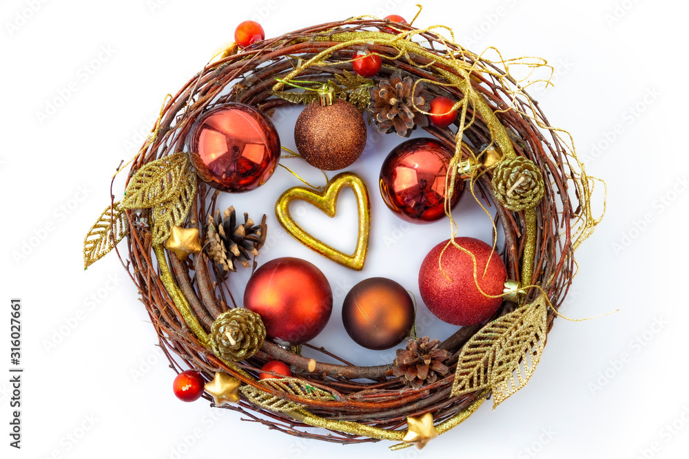 A shiny Christmas wreath made of dried twigs, decorated with balls and other decorations.