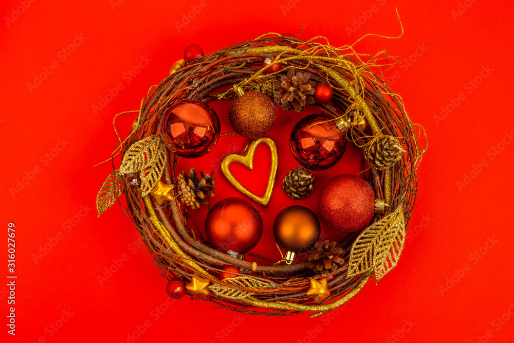 A shiny Christmas wreath made of dried twigs, decorated with balls and other decorations.