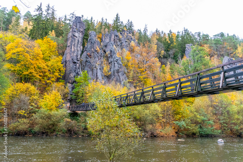 Fototapeta Naklejka Na Ścianę i Meble -  Swing Bridge over Ohre River at Svatos Rocks, Czech: Svatosske skaly, at autumn time, Czech Republic