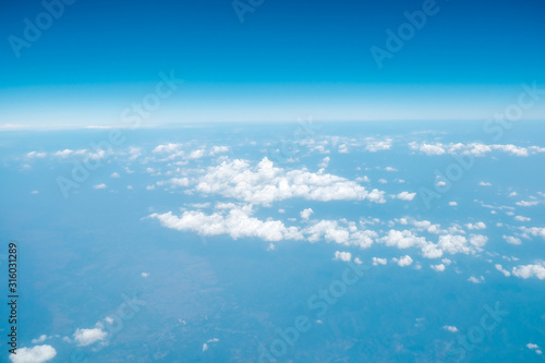 Fluffy white cloud with blue sky above view from airplane