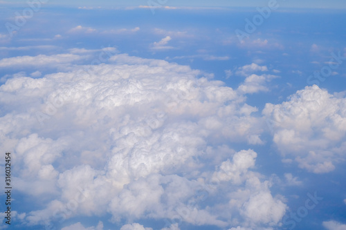 Fototapeta Naklejka Na Ścianę i Meble -  Fluffy white cloud with blue sky above view from airplane