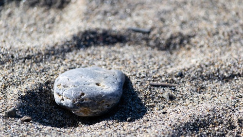A beach stone alone in the sand