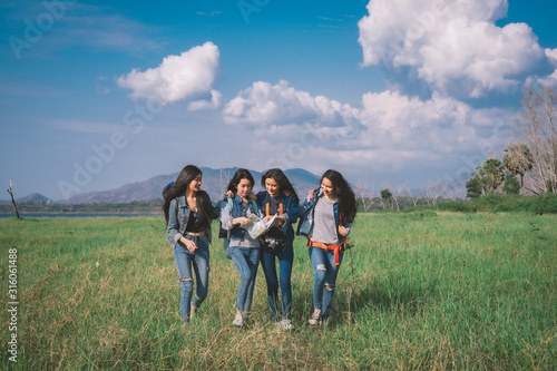 A happy group of tourists having fun travel in nature and meadow.