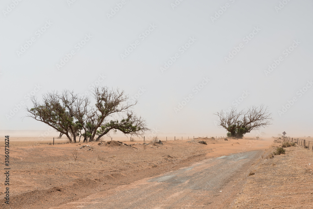 Sand storm in remote Australian agricultural farm field. Climate change or global warming concept for drought as a natural disaster.