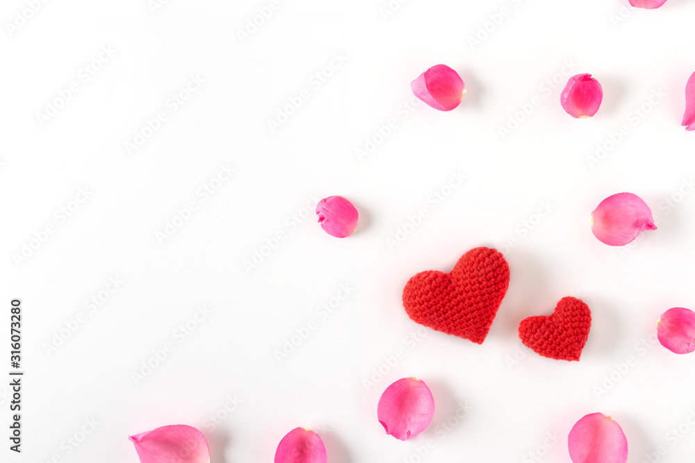 Top view of pink rose petals and red heart on white background.Valentine's day concept. Top view of pink rose petals and red heart on white background.Valentine's day concept.