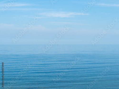 A fishing boat is engaged in fishing in the calm open sea. Baltic sea