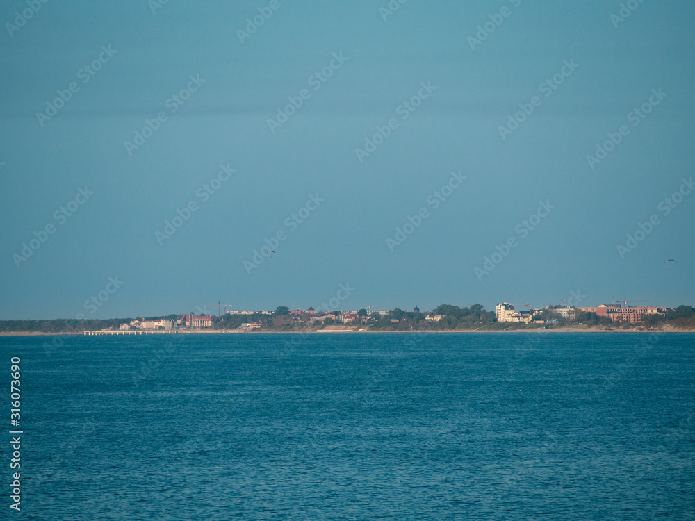 Seascape, calm sea, Zelenogradsk city in the background. Cloudscape, Baltic sea