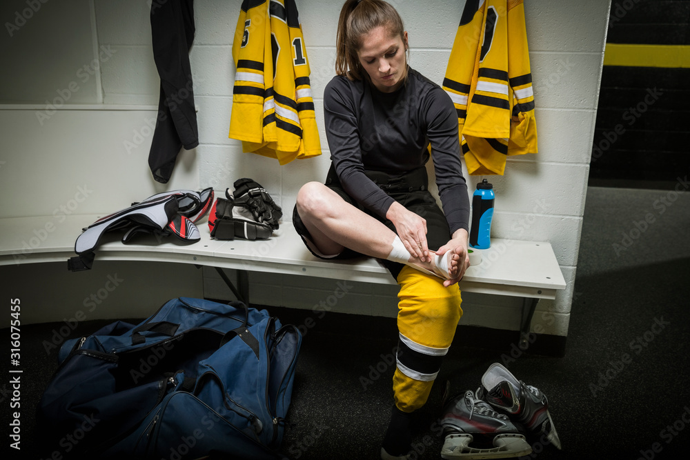 Female ice hockey player taping ankle locker room Stock Photo Adobe Stock