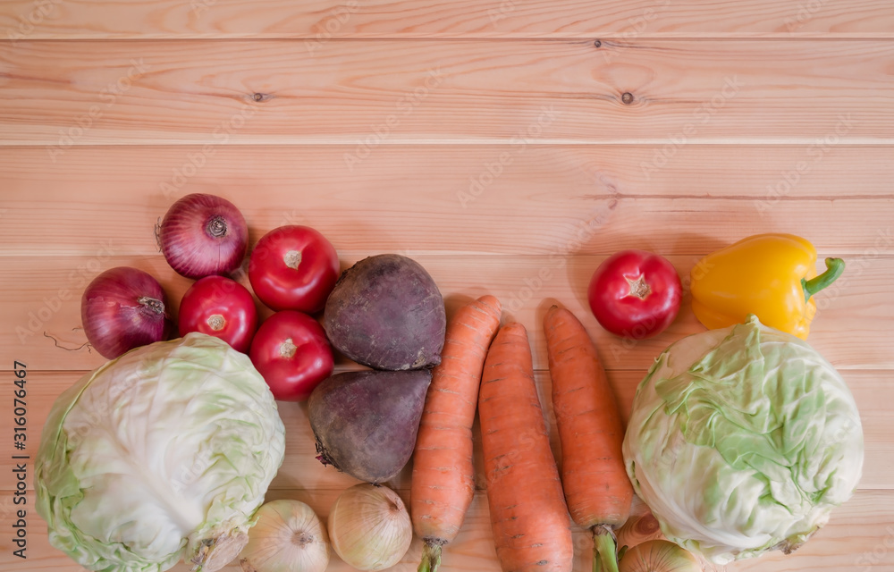 Border made of assorted fresh ripe vegetables on wooden background.