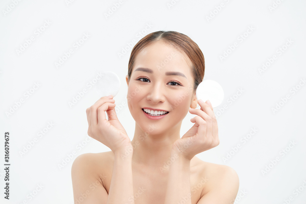 Smiling woman holds cotton pads on white background. Skin care concept. Smiling woman holds cotton pads on white background. Skin care concept.