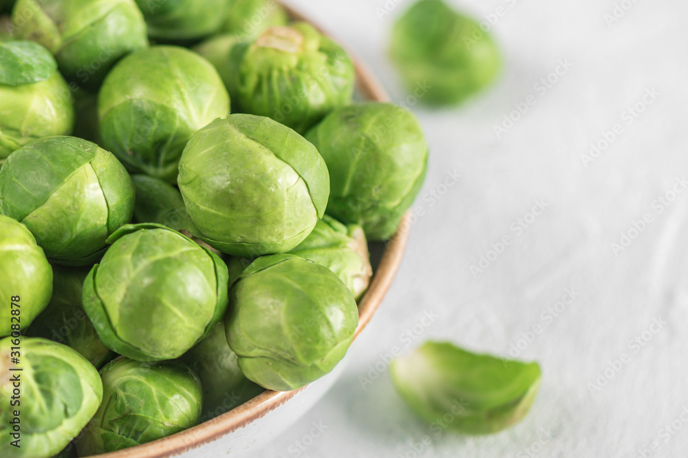 Organic raw and fresh brussel sprouts on a plate on light background Organic raw and fresh brussel sprouts on a plate on light background